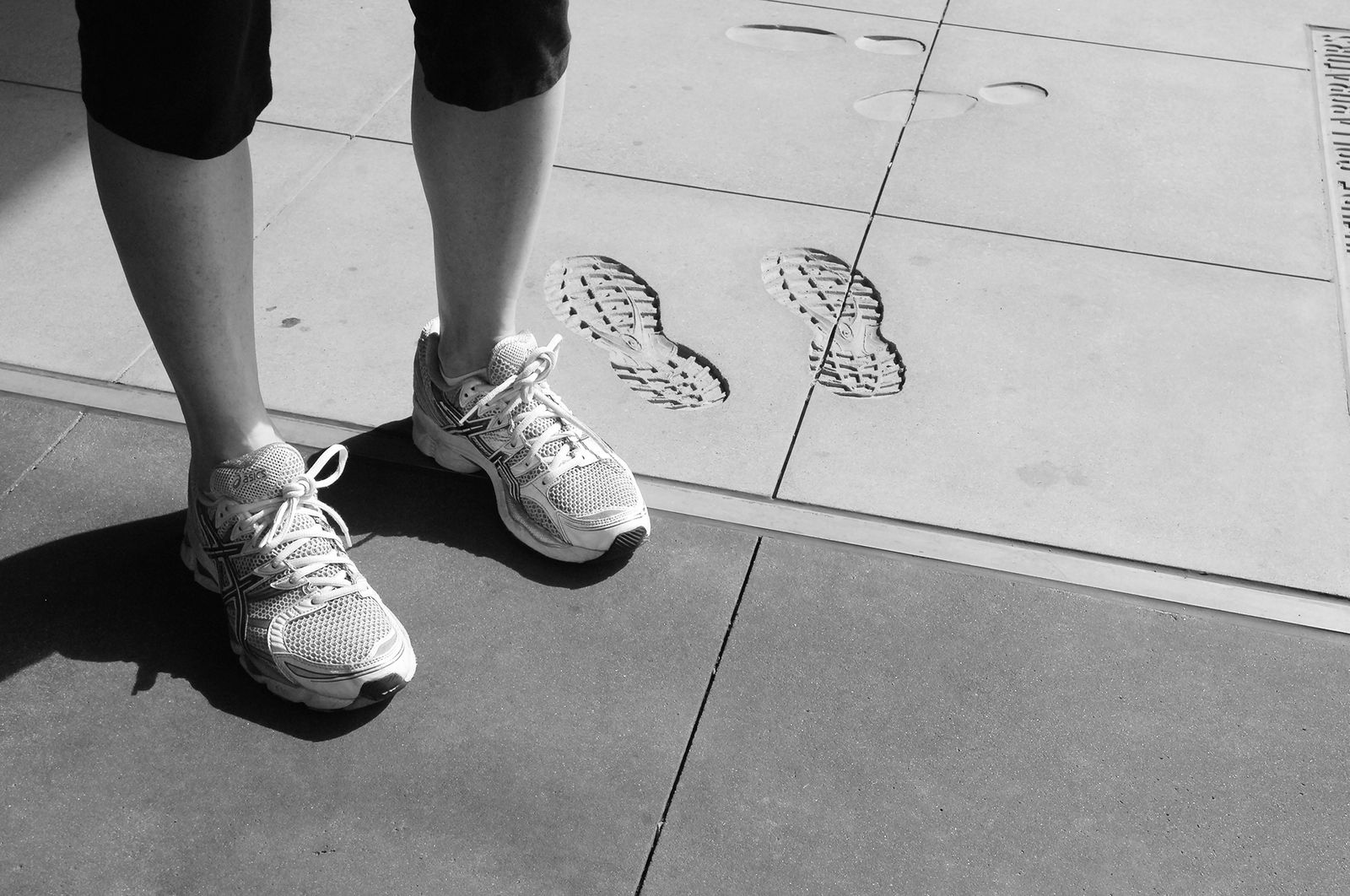 A series of footprints in cement located on the walkway in front of the library